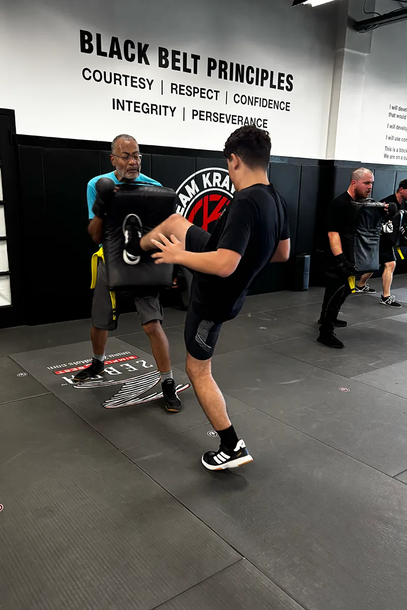 Adult Krav Pro students practicing a controlled partner drill together.