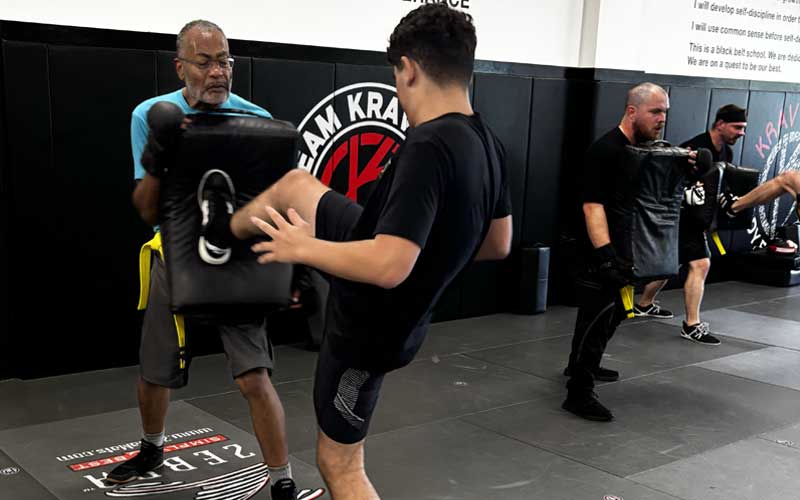 Adult student practicing kick technique in Foundations class at Krav Pro