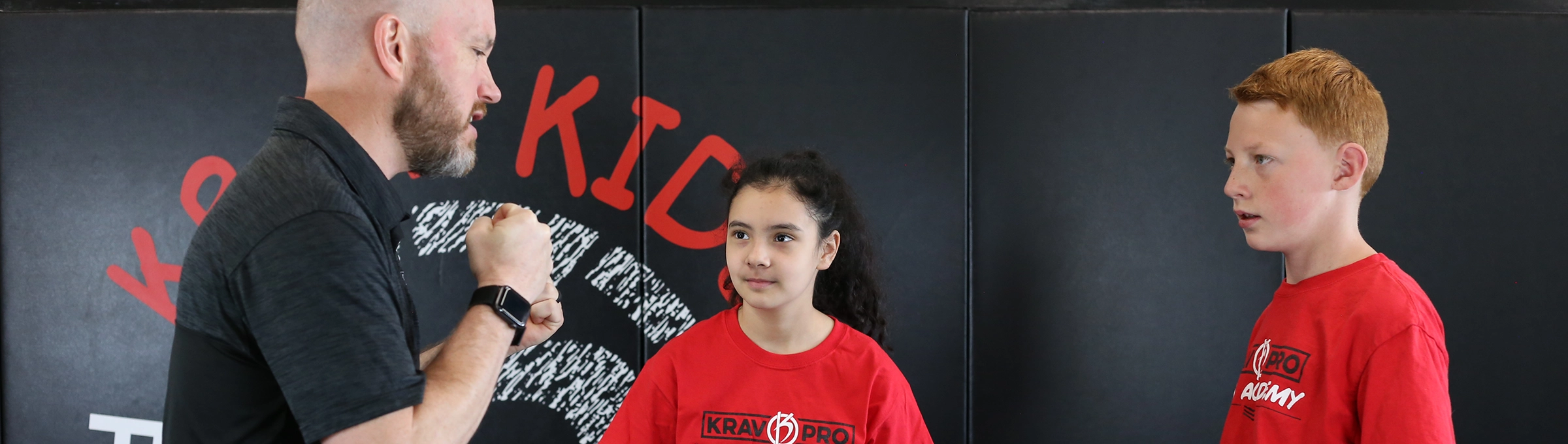 Krav Pro instructor coaching a student during class