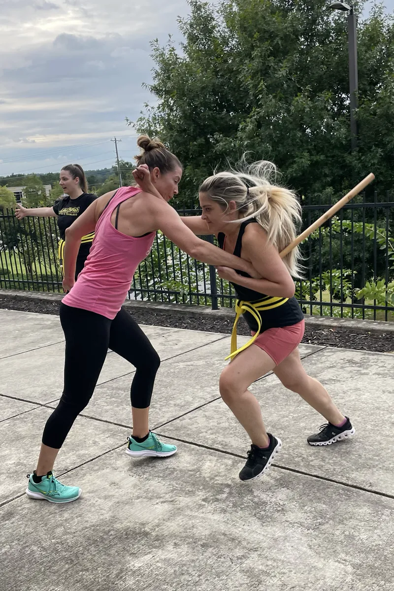 Adult students training with pads during a Krav Pro fitness and self-defense class.