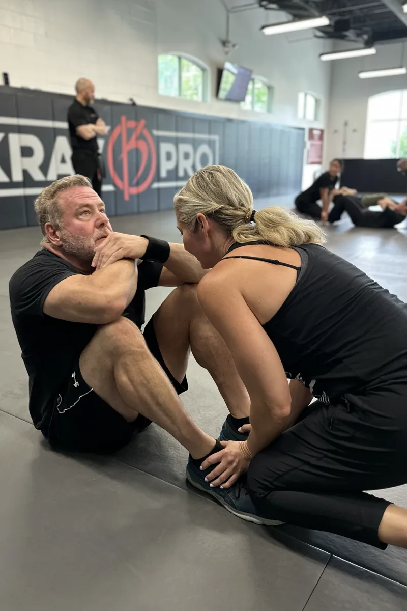 Adult Krav Pro students practicing controlled pad work with instructor coaching.