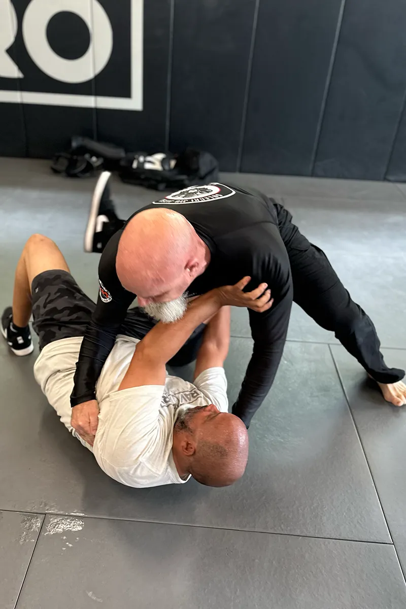 Adult Krav Pro student repeating a new movement after coaching feedback.