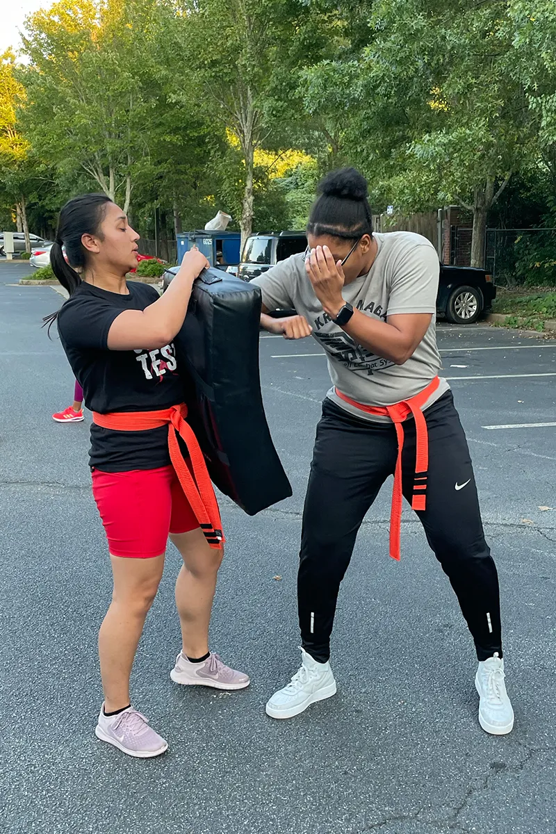 Adult Krav Pro students listening to instruction during a class reset.
