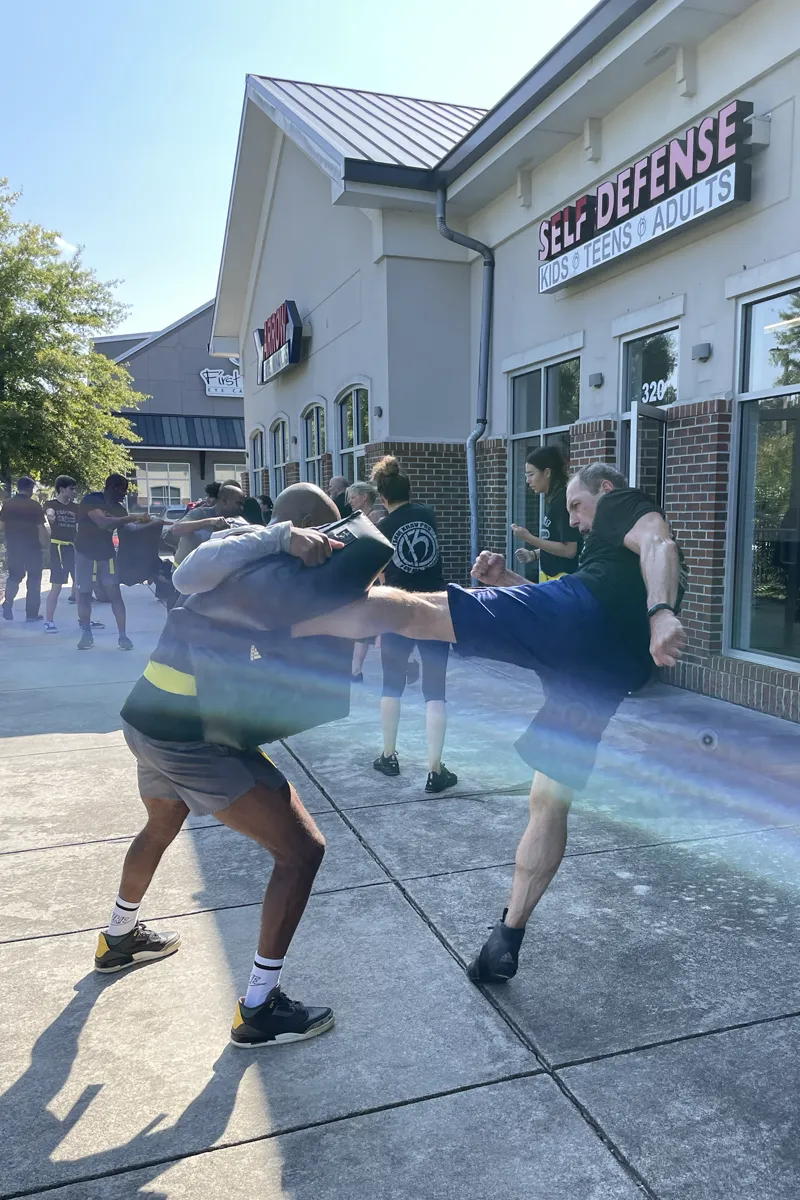 Adult Krav Pro class resetting together between training rounds.