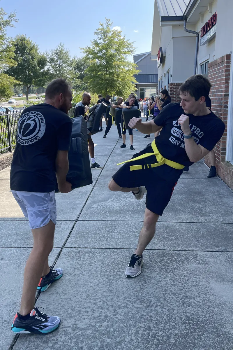 Adult Krav Pro student receiving coaching during a beginner self-defense drill.