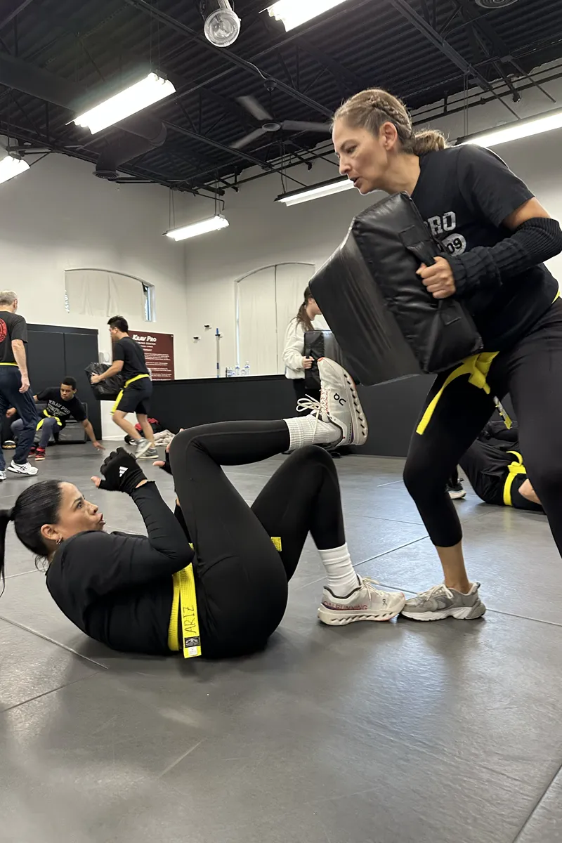 Adult Krav Pro student receiving instructor coaching before a controlled drill.