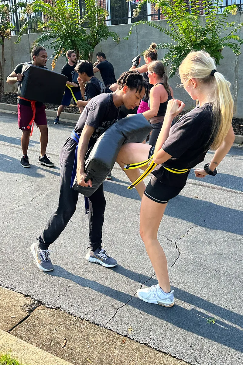 Adult Krav Pro classmates sharing a positive moment between drills.