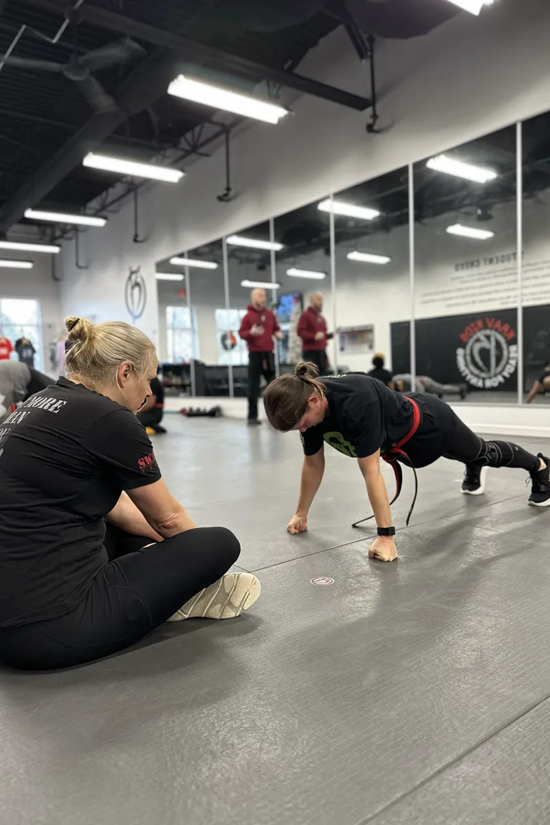 Two adult Krav Pro students communicating during a controlled training reset.